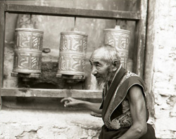 Superior Lama by prayer wheels in monastery on shores of Brahmaputra